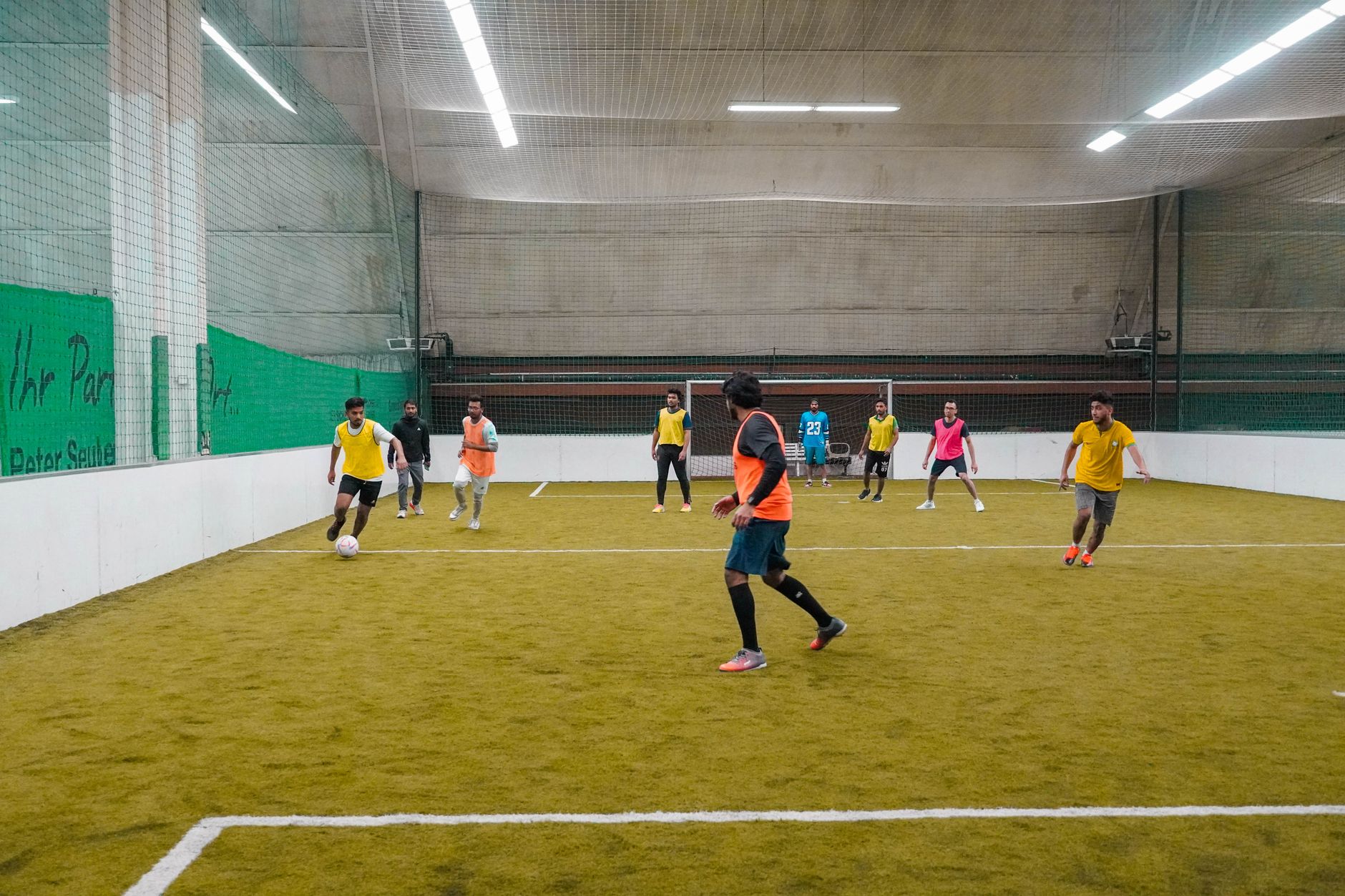 Amatorski mecz futsalu w hali, zawodnicy w różnym wieku i zapałem