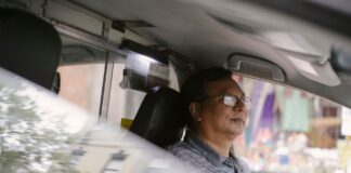 Mindfulness za kierownicą: proste ćwiczenia na codzienne trasy Skupiony azjatycki kierowca w okularach prowadzi auto w mieście