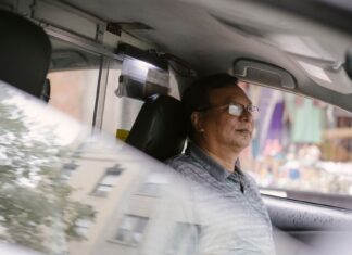 Mindfulness za kierownicą: proste ćwiczenia na codzienne trasy Skupiony azjatycki kierowca w okularach prowadzi auto w mieście