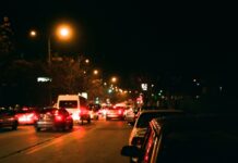 Ćwiczenia z panowania nad autem w korku i podczas częstego ruszania Nocna miejska ulica pełna samochodów i jasnych świateł
