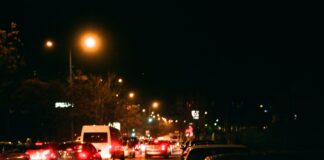 Nocna miejska ulica pełna samochodów i jasnych świateł